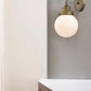 One Light Gold Wall Sconce with Round Glass Shade