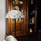 62" Dark Brown Two Light Torchiere Floor Lamp With White Fleur de Lis Glass Dome Shade