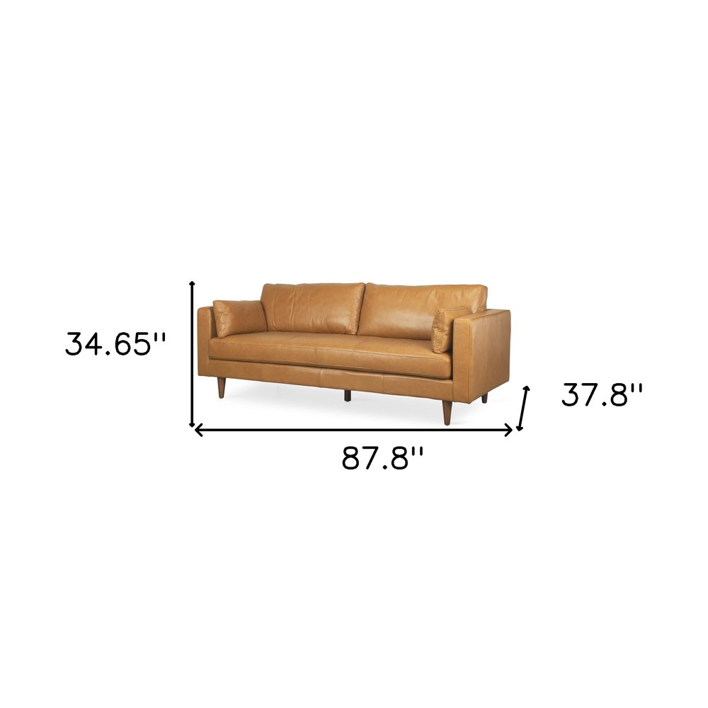 88" Tan Leather Sofa And Toss Pillows With Brown Legs